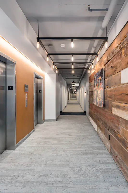 Sienna elevator corridor with artwork and reclaimed wood paneling
