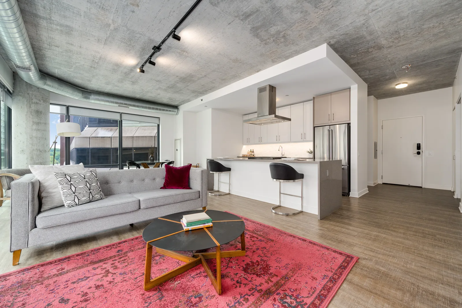 Open living room and kitchen with concrete ceiling in a Sienna residence