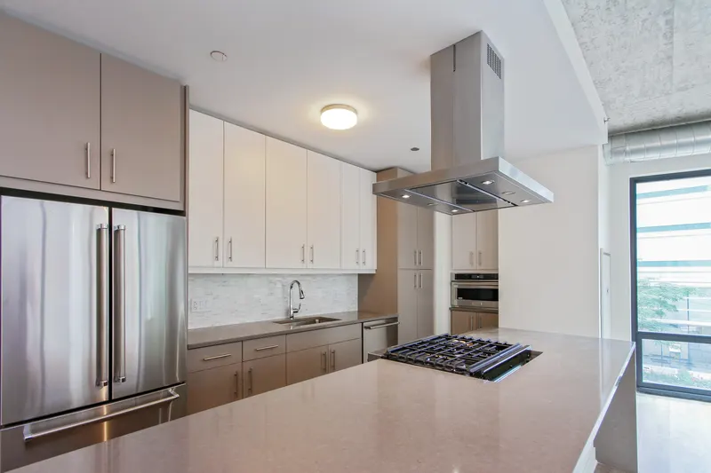 Residence kitchen with stainless steel appliances, island cooktop, and quartz counters