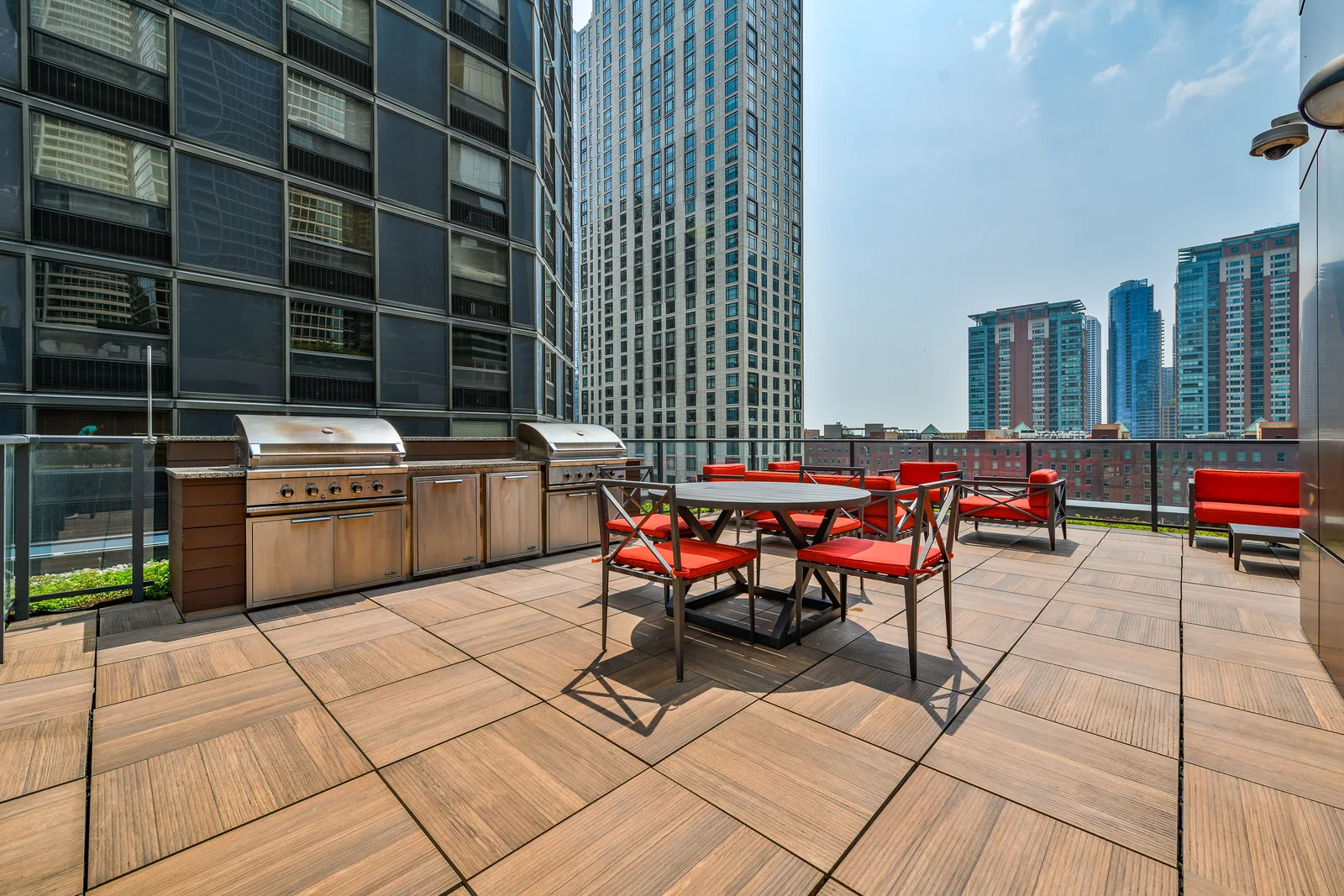 Sienna rooftop terrace with outdoor dining tables, grills, and city buildings
