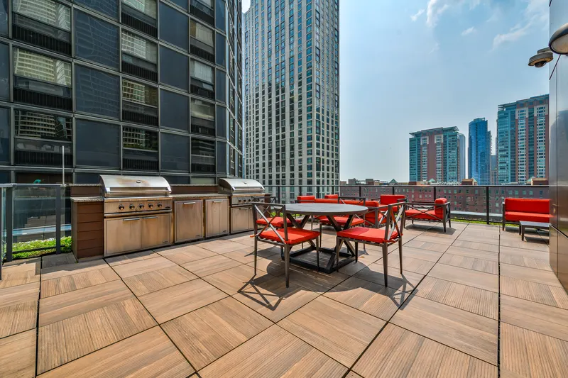 Sienna rooftop terrace with outdoor dining tables, grills, and city buildings